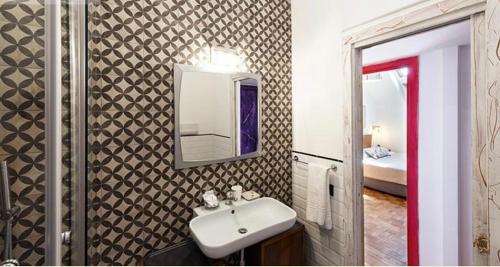 ein Bad mit einem Waschbecken und einem Spiegel in der Unterkunft Mansarda Bellini 84 in Neapel