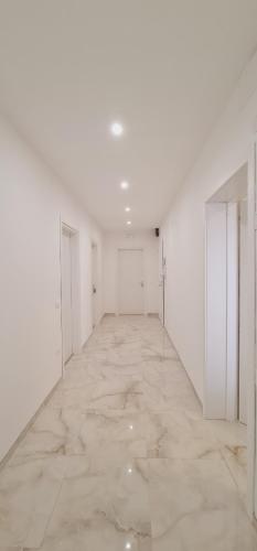 an empty room with white walls and a marble floor at Farah’s house in Padova