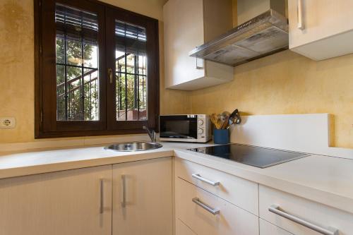 a kitchen with a sink and a microwave at Apartamento Puerta Elvira Centro in Granada