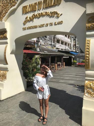 a woman in a white dress standing in front of a building at Mae Chan Treehouse with swimming pool in Mae Chan