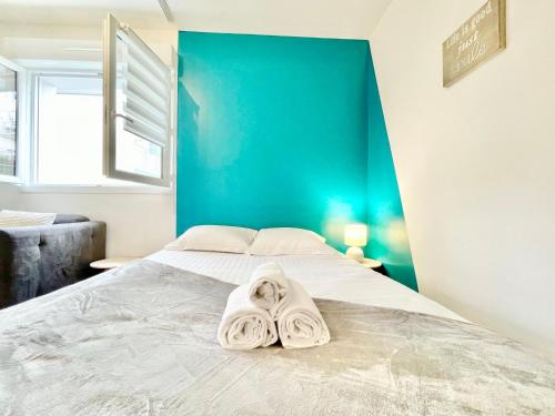 a bedroom with a bed with towels on it at Saint Nazaire - Le Sembat - Proche mer - Wifi fibre in Saint-Nazaire