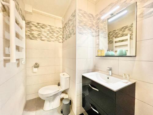 a bathroom with a toilet and a sink and a mirror at Saint Nazaire - Le Sembat - Proche mer - Wifi fibre in Saint-Nazaire