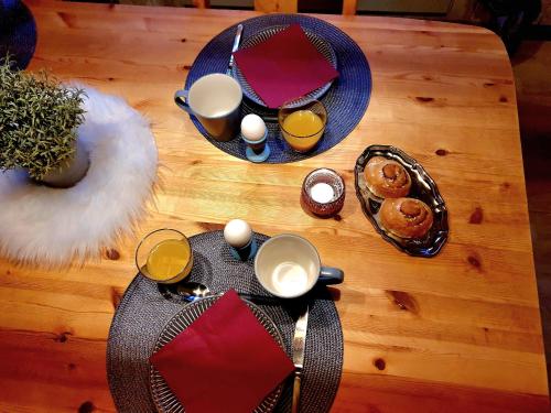 a table with food and drinks on a wooden table at Schnieders2German forest B&B in Harmånger