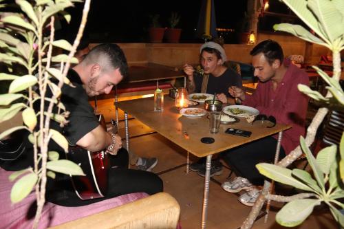 a group of men sitting at a table in a restaurant at Hotel Pol Haveli Jaisalmer in Jaisalmer