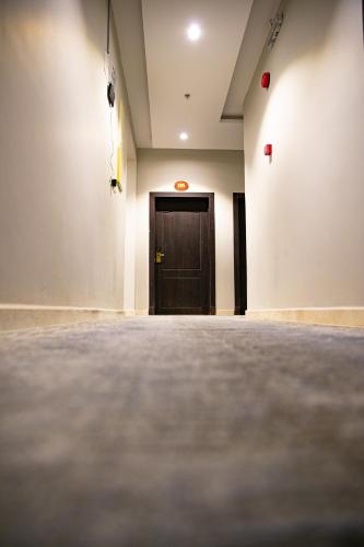 an empty room with a wooden door in the middle at روش بلس للشقق المخدومة in Hafr Al Baten