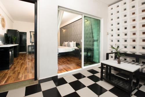 a room with a checkered floor and a bedroom at The Sanctuary Residence in Siem Reap
