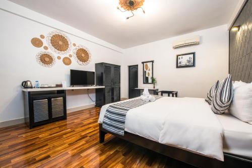 a bedroom with a bed and a desk at The Sanctuary Residence in Siem Reap