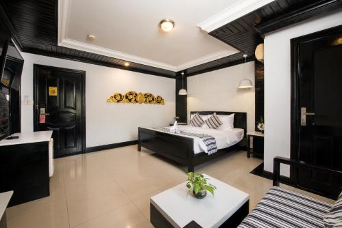a hotel room with a bed and a couch at The Sanctuary Residence in Siem Reap