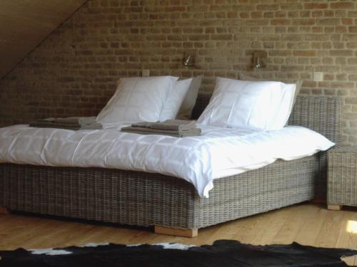 een groot bed in een kamer met een bakstenen muur bij B&B Schoon Goed in Gingelom