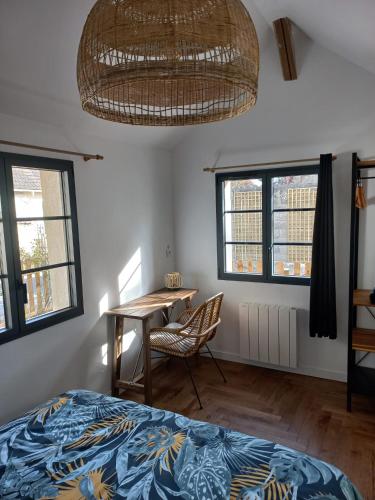 Schlafzimmer mit einem Bett, einem Tisch und Fenstern in der Unterkunft Villa Cosy Pierrefonds in Pierrefonds