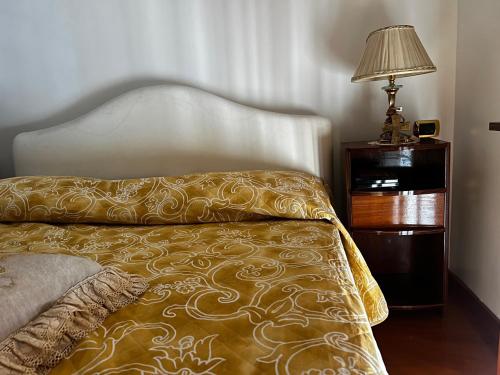 una camera da letto con un letto con una lampada e un comodino di Residenza Borgo Marinaro a Napoli