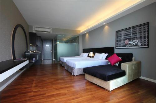 a bedroom with a large white bed and a bench at The Shore Hotel & Residences By Lá VISTA in Melaka