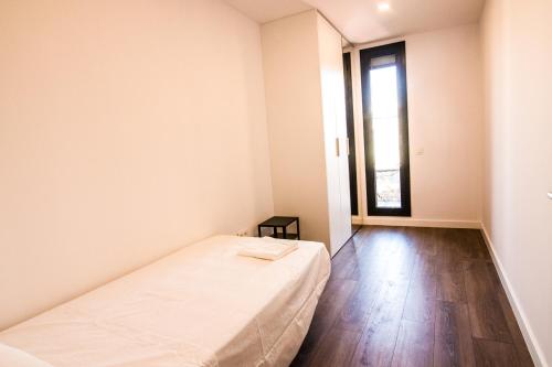 a white room with a bed and a window at 3-1 Apartamento de diseño en el centro de Reus in Reus