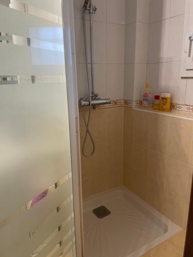 une douche avec une porte vitrée dans une salle de bain dans l'établissement Chambre d’hôte, à Chailly-en-Bière