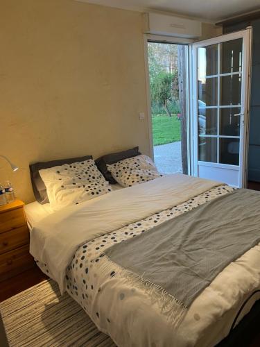 a large bed in a bedroom with a sliding glass door at Chambre d’hôte in Chailly-en-Bière