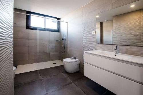 bagno con lavandino, servizi igienici e specchio di Atico con terraza en el centro de Reus a Reus