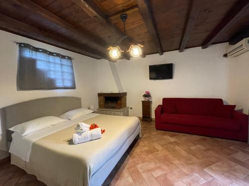 a bedroom with a bed and a red couch at La CASETTA di Antonietta in Fiumicino