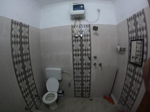 a bathroom with a toilet and a shower at Hobbit House Hostel in Rishīkesh