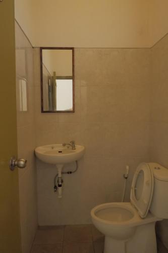 a bathroom with a sink and a toilet and a mirror at Baik Baik Homestay in Uluwatu