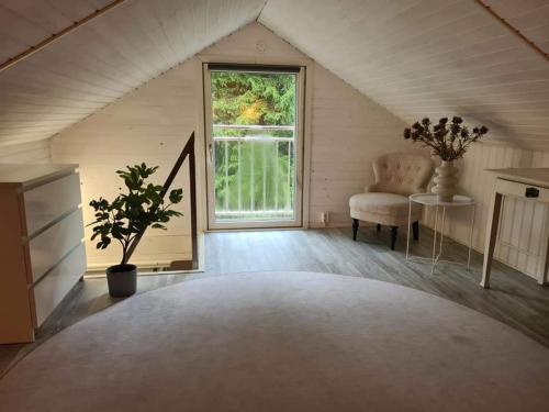 sala de estar con ventana grande y silla en Pinebo Palace Guesthouse, en Ulricehamn