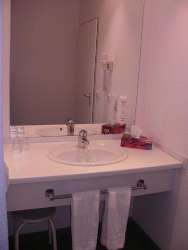La salle de bains est pourvue d'un lavabo et d'un miroir. dans l'établissement Center Hotel Drive Inn, à Hirschaid