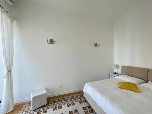 a white bedroom with a bed and a window at Casa Giusi in Capri