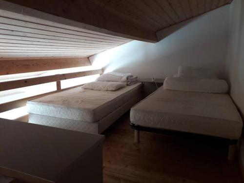 deux lits dans une petite pièce avec une fenêtre dans l'établissement Maison calme proche mer - La Roseraie, à Saint-Hilaire-de-Riez