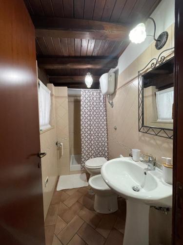 a bathroom with a white sink and a toilet at La CASETTA di Antonietta in Fiumicino