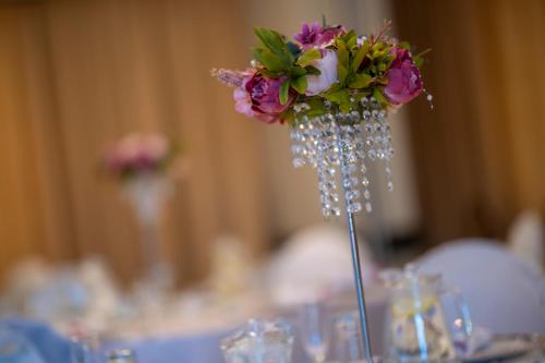 a vase with a bouquet of flowers on a table at The Balmoral - Halaal in Durban