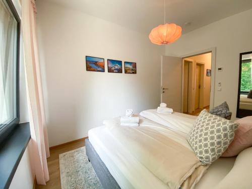 ein Schlafzimmer mit einem großen weißen Bett und einem Fenster in der Unterkunft Apartment Aria Velden in Velden am Wörthersee