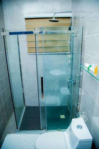a glass shower in a bathroom with a toilet at Best Lodge in Tamale