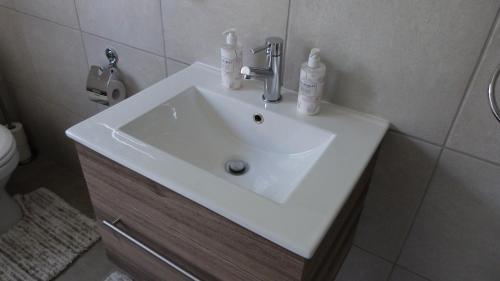 a white sink in a bathroom with a toilet at Settle inn Self Catering Units in Colchester