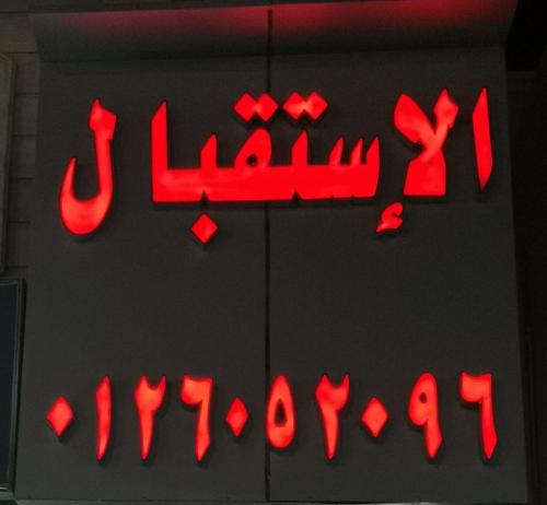a neon sign with red writing on a wall at سارة للشقق المفروشة - الحمدانية جدة in Ḩayy aş Şāliḩīyah