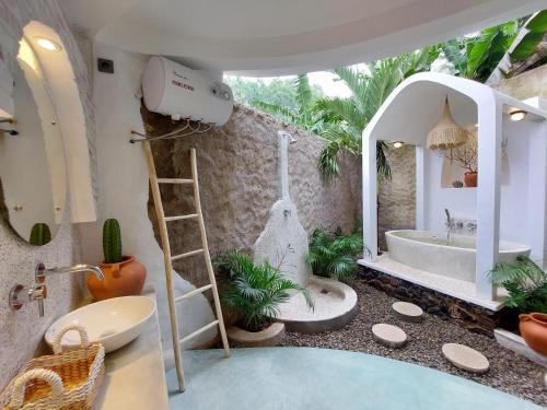 a bathroom with a bath tub and a sink at OMA WATU DOME VILLAS in Pacitan