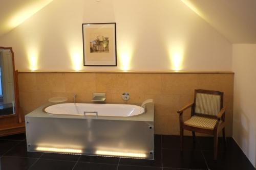 a bath tub in a bathroom with a chair at Wohnen am Dehnthof Haus 2 in Kappeln