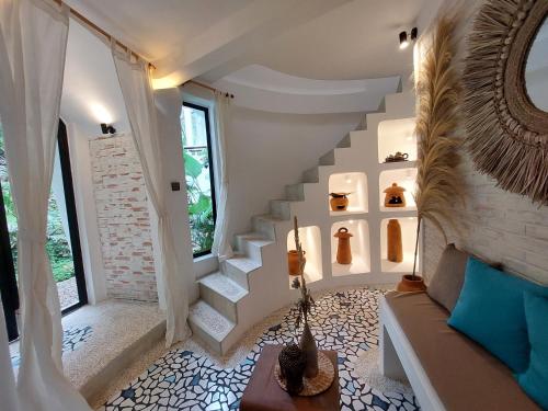 a living room with a staircase and a couch at OMA WATU DOME VILLAS in Pacitan