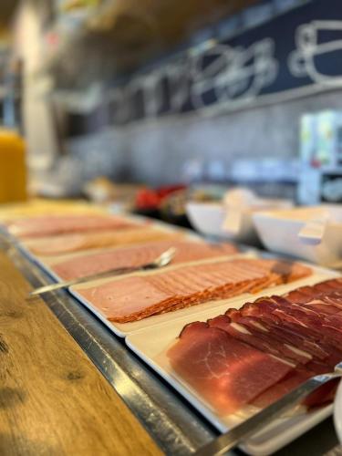 a buffet line with different types of meat on plates at ibis budget Muenchen Putzbrunn in Putzbrunn