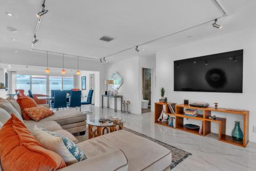 uma sala de estar com dois sofás e uma televisão em Sandcastles & Sunshine at Towering Palms of Wilton Manors residence em Fort Lauderdale