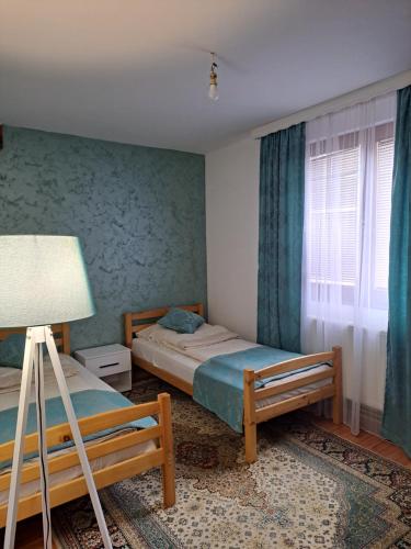 1 dormitorio con 2 camas y ventana en Apartman Lara 2, en Foča