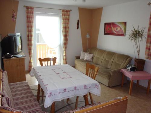 ein Wohnzimmer mit einem Tisch und einem Sofa in der Unterkunft Ferienhaus Stockinger in Jandelsbrunn