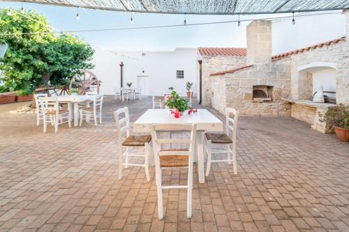 a white table and chairs on a patio with a fireplace at B&B Villa Flora in Santeramo in Colle