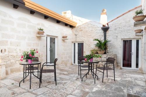 a patio with two tables with chairs and flowers at B&B Villa Flora in Santeramo in Colle
