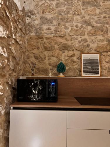 a microwave on top of a counter in a stone wall at ACANTO -Viaggio Barocco in Ragusa