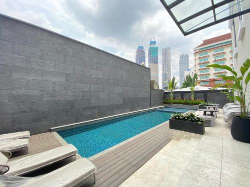 uma piscina ao lado de um edifício em Maia Hotel Jakarta em Jacarta