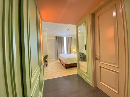 a room with a bedroom with a bed and a mirror at Maia Hotel Jakarta in Jakarta