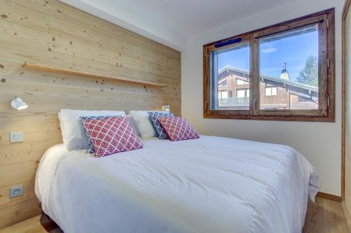 une chambre avec un lit blanc avec une fenêtre dans l'établissement Echo du Pleney B101, à Morzine