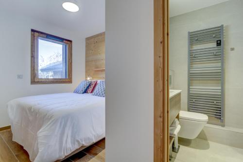 une chambre avec un lit et des toilettes et une fenêtre dans l'établissement Echo du Pleney B101, à Morzine