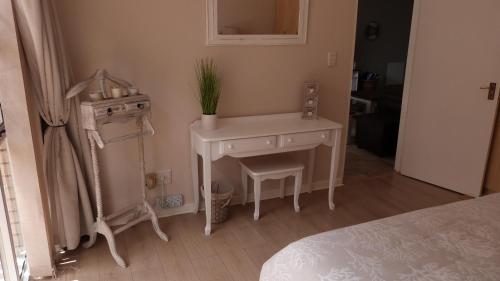 a bedroom with a white desk and a plant on it at Settle inn Self Catering Units in Colchester