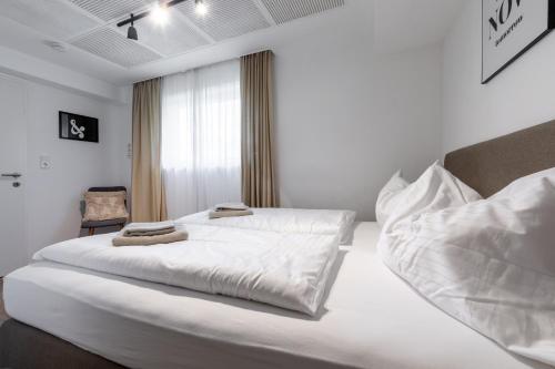 a bedroom with a large white bed with towels on it at Appartements DAS RETTENBACHER in Schladming