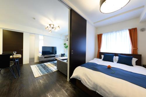 a bedroom with a large bed and a television at GLASS Yamahana EAST in Minami-jūichijō